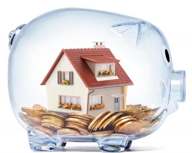 House on money inside transparent piggy bank with clipping path